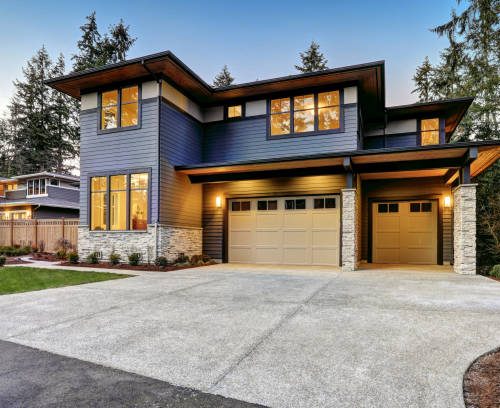 Luxurious new construction home in Bellevue, WA. Modern style home boasts two car garage framed by blue siding and natural stone wall trim. Northwest, USA