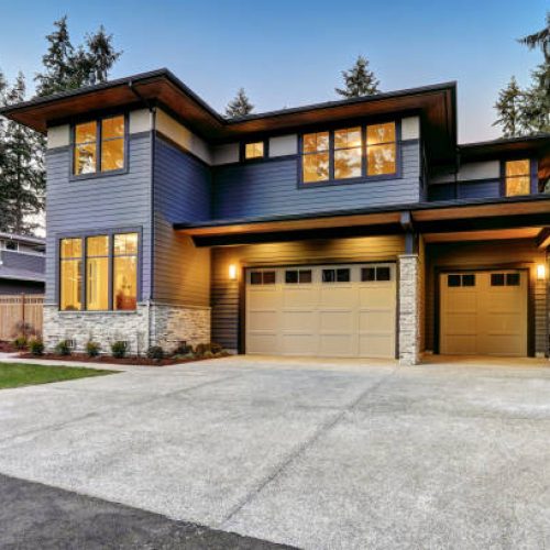 Luxurious new construction home in Bellevue, WA. Modern style home boasts two car garage framed by blue siding and natural stone wall trim. Northwest, USA