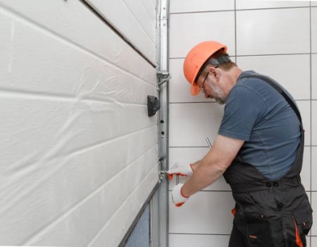 The worker is installing the lifting gates of the garage.