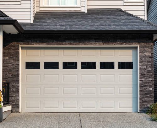 Garage Door. Modern house with garage door that is closed. A perfect neighborhood. Family house with wide garage door and concrete driveway in front. Street photo, nobody